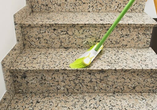 Reinigung eines Treppenhauses mit einem Besen